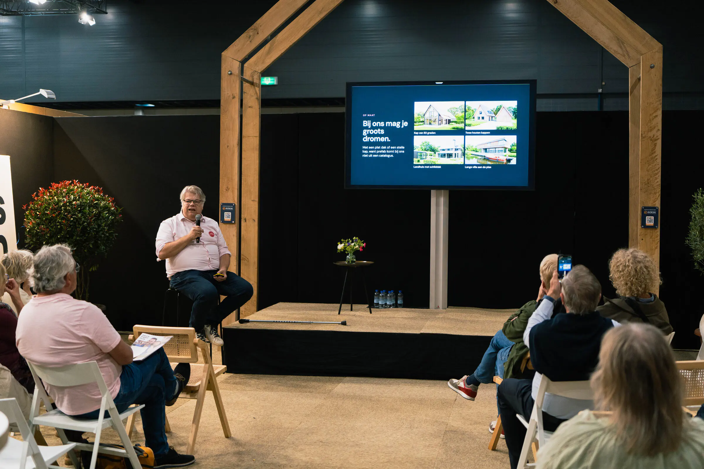 Volle zaal bij de lezing van eVilla op Beurs Eigen Huis. Op het scherm staat: Bij ons mag je groots dromen.