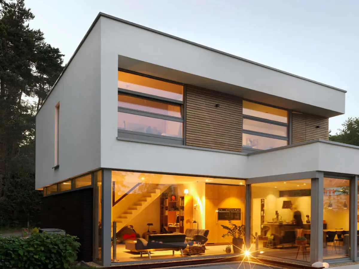 Gebouwde prefab woning met een hoge woonkamer en grote ramen