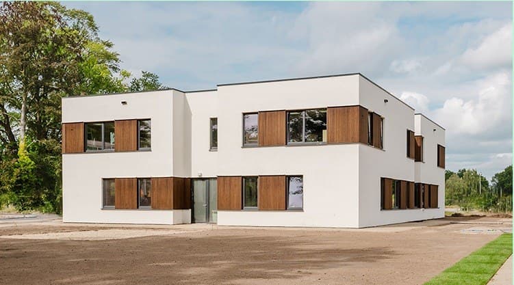 Wit gebouw met houten kozijnen voor dagbesteding, met ruime entree